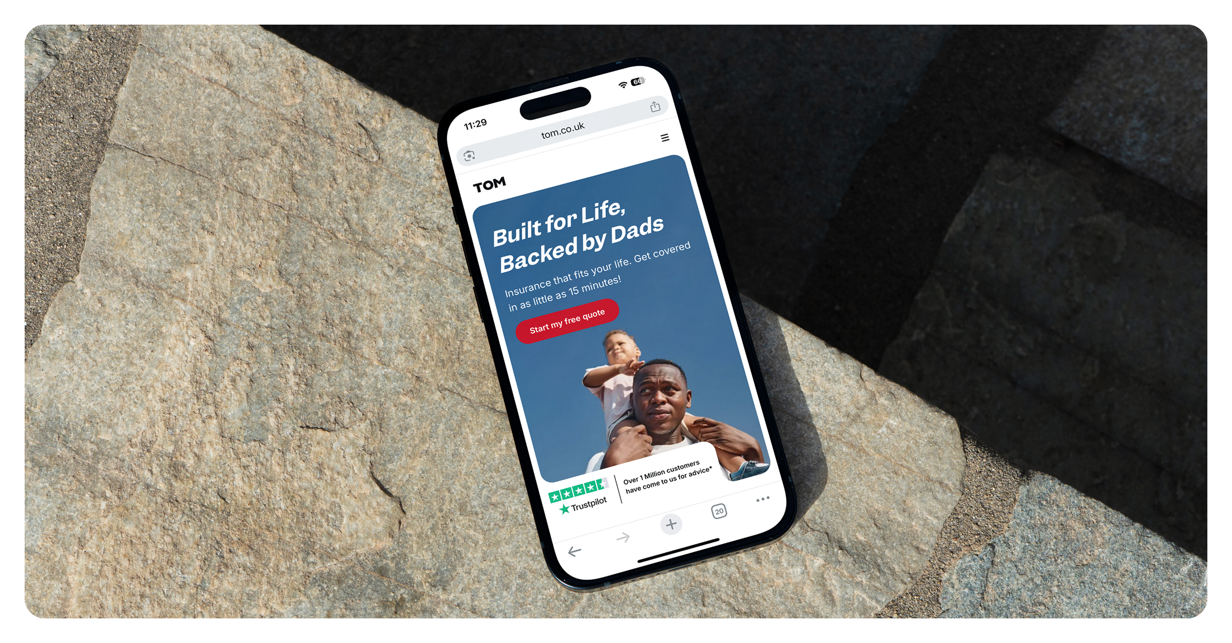 TOM website on phone — stone surface